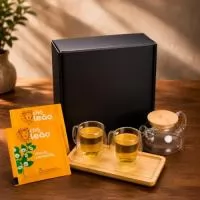 Kit Chá Tè Reale em caixa para presente VIP assinada Youdu. Contém 2 canecas de vidro de parede dupla de 250ml, bule de vidro borossilicato com infusor em aço inox, travessa em bambu para servir e chá envelopado em sachê sabor camomila.