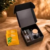 Kit Chá Tè Momento em caixa para presente VIP assinada Youdu. Contém 2 canecas de vidro de parede dupla de 250ml, bule de vidro borossilicato com infusor em aço inox, travessa em bambu para servir e chá envelopado em sachê sabor camomila.