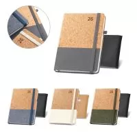 Agenda B5 em cortiça e linho. Possui um suporte para esferográfica (não inclusa), marcador em fita e elástico para fecho na mesma cor. Está organizada num plano diário. Fornecida com bolsa de non-woven. 148 x 210 mm | Bolsa: 205 x 250 mm
