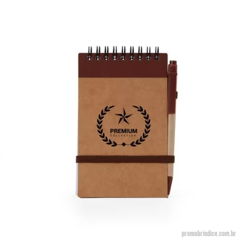 Bloco Anotações personalizado - Bloco de anotações ecológico com caneta, feito em Kraft com detalhe plástico. Contém aproximadamente 70 folhas brancas com pauta, porta caneta elástico, elástico para lacre e acompanha caneta de papelão com detalhes plásticos, carga esferográfica azul 1.0mm e acionamento por clique.