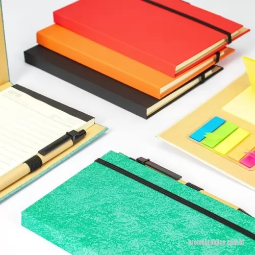 Bloco Anotações personalizado - Descrição: Bloco de anotações com capa dura revestida em papel especial e fita elástica para fechamento. Possui cerca de 80 folhas pautadas, além de um bloco com aproximadamente 20 folhas autoadesivas amarelas e por volta de 100 marcadores de página autoadesivos, divididos em cinco cores diferentes. Acompanha uma caneta esferográfica com carga azul de 1.0mm e acionamento por clique, corpo em papelão e demais componentes em plástico.  Largura :  13 cm  Espessura :  1,4 cm  Comprimento :  18 cm  Medidas aproximadas para gravação (CxL):  18 cm x 9,5 cm (capa) - 0,8 cm x 10 cm (caneta)