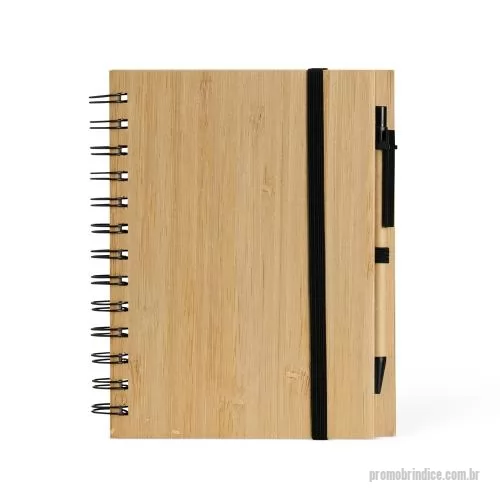 Bloco personalizado - Caderno ecológica com caneta. Capa de papelão com folha similar ao bambu. Possui aproximadamente 70 folhas brancas pautadas com logo reciclado na lateral inferior. Acompanha suporte elástico de nylon com uma caneta de papelão de detalhes plásticos.