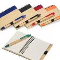Caderno com capa em casca de bambu, faixa decorativa colorida na vertical, porta-caneta em elástico, encadernação Wire-O e cerca de 70 folhas pautadas. Acompanha uma caneta esferográfica de carga azul de 0,8 mm com corpo em papelão e clip, acionamento em clique e ponteira em plástico.  Largura :  10,5 cm  Comprimento :  13,5 cm  Espessura :  1 cm