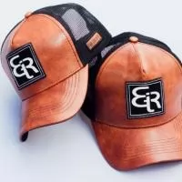Bonés modelo Trucker Tecido em Couro, com Telinha, Regulador de Plástico. 