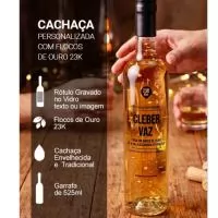 . Cachaça envelhecida em madeira de Amburana, de cor amarelada*   . Rótulo Personalizado gravado direto no Vidro com TEXTO / IMAGEM (não é adesivo)  . Garrafa de vidro de 525 ml  . Flocos de Ouro próprios para alimentos e bebidas