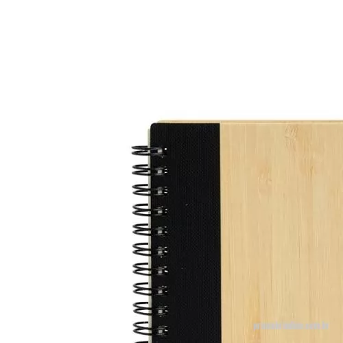 Caderno ecológico personalizado - Um caderno feito para quem deseja anotar ideias e projetos sem abandonar a preocupação com o meio ambiente. Com capa feita em casca de bambu e faixa vertical colorida, ele conta também com encadernação Wire-O e aproximadamente 70 folhas amareladas pautadas. Além disso, o caderno acompanha uma caneta esferográfica de carga azul de 0,8 mm com corpo em papelão e clip, acionamento em clique e ponteira em plástico. A capa contém um elástico para abrigar a caneta junto ao caderno.