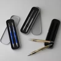 Conjunto de caneta e lapiseira metálicas em estojo de metal. Caneta e lapiseira possuem acabamento fosco, detalhe emborrachado na parte inferior, carga esferográfica azul de 1.0mm e acionamento por clique. Estojo revestido em espuma.