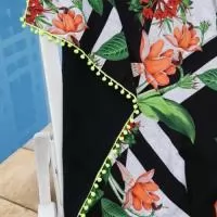 Canga de tactel de um lado e de outro tecido atoalhado. Acabamento em franja ou pompom.