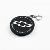 Chaveiro Emborrachado, Gravação em Alto relevo com a logo do cliente. Desenvolvimento de formato específico. Acabamento em cordão de nylon e argola (ou em corrente metálica e argola).