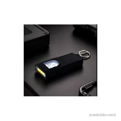 Chaveiro lanterna personalizado - Chaveiro lanterna recarregável com estrutura em plástico. Possui duas fontes de iluminação em LED, com quatro níveis de intensidade em luz branca e modo piscante nas cores azul e vermelha, acionados por botão lateral. Conta ainda com base magnética para fixação em superfícies metálicas, entrada USB-C para carregamento e mosquetão metálico fixo. Acompanha cabo USB-C.