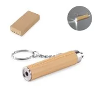 Chaveiro em bambu e ABS, com lanterna LED. Tem incluso 3 pilhas LR41. Fornecido em caixa presente de papel kraft. A cor e o resultado da impressão nos materiais naturais pode variar entre produtos. ø15 x 75mm