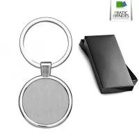 Chaveiro de metal em formato redondo, possui chapa frontal em metal e verso liso, acompanha caixinha na cor preto, tamanho aproximado 7,8x3,3cm.