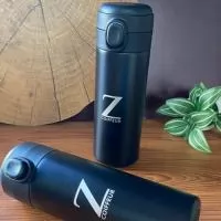 Garrafa térmica em inox com parede dupla, capacidade de 400ml. Tampa com botão central para abertura e borracha interna para vedação.