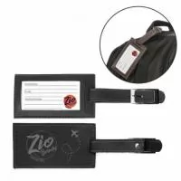 Identificador de bagagem e mala Personalizado | Identificador de Bagagem – IB9 pode ser confeccionado em couro ou sintético nobre diversas opções de materiais e cores (modelo da foto principal foi confeccionado no sintético bidim preto). Possui local com visor interno para cartão de identificação. Fechamento através de lingueta com fivela e rebite níquel. Personalização com gravação em baixo relevo ou silkscreen 1 cor. - ZIO BRINDES