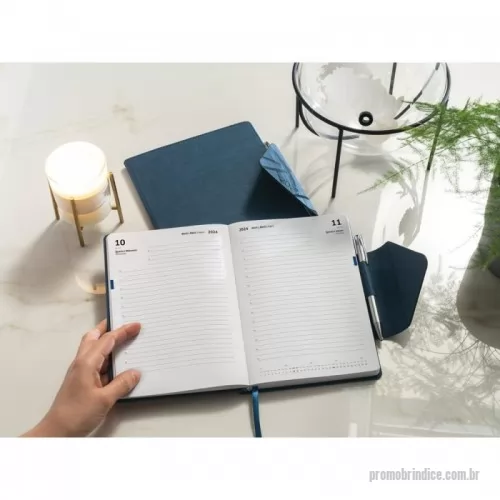 Kit agenda personalizado - Agenda A5 em PU com fecho magnético. Está organizada num plano diário. Com suporte para esferográfica (incluída) e marcador em fita. Fornecida com bolsa de non-woven. 148 x 210 mm | Bolsa: 205 x 250 mm