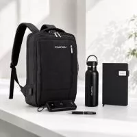 MOCHILAde poliéster 21 litros com bolso para  notebook 15,6 e bolso sanfonado Com divisórias  internas para acessórios, a mochila possui suporte  externo USB, alça para engate em malas de viagem  e duas alças de mãos, sendo uma delas para o  transporte da mochila no formato pasta. CADERNETAcapa dura em couro sintético com  fecho magnético, placa metálica personalizável,  além de marca-página em fita de cetim e  aproximadamente 96 folhas brancas pautadas.  TAM.: 15 x 21 x 2,1cm GARRAFA TÉRMICA feita em Inox 304 com parede  dupla e capacidade de 550ml. Com tampa  rosqueávele alça para transporte para levá-la  onde quiser. POWER BANK em plástico com capacidade de  20.000mAh, painel de LED , alça para transporte e  suporte lateral..