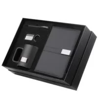 Kit escritório contendo caderno A5 com placa metálica na capa para personalização, caneta esferográfica em alumínio, caneca de cerâmica com capacidade de 350ml e chaveiro metálico.