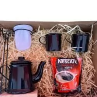 2 Canecas de Alumínio de 90ml (Consulte as Opções de Cores) 1 Bule de Café de Alumínio de 180ml (Consulte as Opções de Cores) 1 Suporte com Base de madeira e bocal para o Mini Coador (Consulte as Opções de Cores) 1 Mini Coador de Algodão 1 Pacote de Nescafé 1 Caixa Kraft