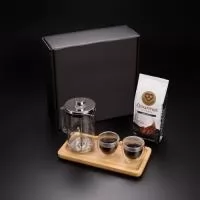 Kit VIP Café Gourmet apresentado em uma sofisticada caixa de presente, ideal para quem aprecia uma experiência completa ao degustar café. O kit inclui um conjunto de xícaras para café em vidro isotérmico de parede dupla (80ml), que mantém a temperatura por mais tempo. Acompanha uma prensa francesa em vidro borosilicato e aço inox (740ml), garantindo uma extração rica em sabor e aroma. Para completar, um pacote de café gourmet (250g), selecionado para proporcionar uma experiência única. Um brinde exclusivo e sofisticado da Youdu Brindes.