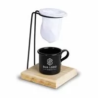 Kit café composto por três itens: xícara metálica com capacidade máxima de 90ml, base de madeira com suporte de metal para coador e um mini coador de café em tecido.