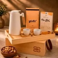 Kit café gourmet Legno em caixa de madeira ecológica com tampa-bandeja. Contém 2 xícaras de porcelana de 170ml com pires de madeira, garrafa térmica retrô de 1000ml, café moído especial Clássico de 250g, lata de biscoitos amanteigados de 160g e caixa de pão de mel de 160g.
