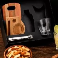 Kit Caipirinha completo com tábua, base, amassador, colher e faca de mesa em madeira e inox. Inclui 2 copos de vidro de 350ml, coqueteleira inox de 350ml, pegador de gelo em aço inox, mix de castanhas e amendoim de 100g e caixa para presente VIP.