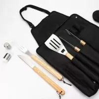 	Kit churrasco 8 peças em estojo de nylon. Contém espátula, garfo, faca, pegador, saleiro, paliteiro, luva e avental (também utilizado como estojo). Talheres de inox com acabamento de madeira e avental de nylon com alça ajustável – possui botão e alça com fivela para lacre.