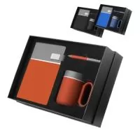 Kit escritório contendo caderno tamanho A5 com capa dura em PU cinza, detalhes em PU colorido e impressão de linhas prateadas, 80 folhas internas pautadas em papel 70g/m², com fechamento magnético em PU e placa metálica, além de caneta esferográfica metálica e caneca de cerâmica. Gravação da logomarca em 1 cor já incluso..