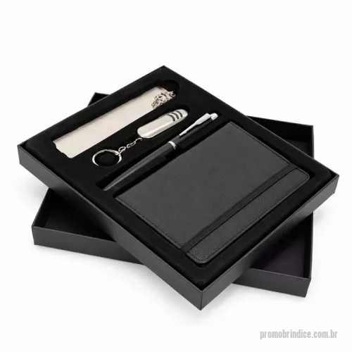 Kit executivo personalizado - Kit executivo composto por quatro itens: caderneta, caneta, canivete e marcador de página. A caderneta possui capa em poliuretano (PU), elástico para fechamento, marca-página em fita de cetim e aproximadamente 76 folhas marfim pautadas. A caneta metálica conta com tampa e carga esferográfica preta de 0,7mm. O canivete em inox apresenta três funções diferentes: lâmina de corte, lixa de unha e uma mini tesoura. O marcador de páginas metálico dispõe de chapa lisa personalizável nas duas faces. Acompanha caixa em papelão com berço removível em plástico de acabamento aveludado para acomodação dos itens do conjunto.
