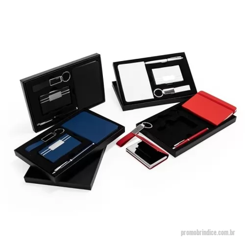 Kit executivo personalizado - Kit composto por quatro itens: caderneta, caneta, porta-cartão e chaveiro. A caderneta possui capa em poliuretano (PU), marca-páginas em fita de cetim e aproximadamente 76 folhas marfim pautadas. A caneta metálica conta com tampa e carga esferográfica preta de 0,7mm. O porta-cartões apresenta estrutura em inox com revestimento externo em PU e interior aveludado, além de plaquinha frontal personalizável. O chaveiro é construído em PU texturizado com argola e chapa em liga de zinco. Acompanha caixa em papelão com berço removível em plástico de acabamento aveludado para acomodação dos itens do conjunto.