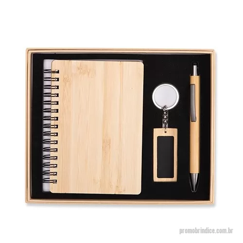 Kit executivo personalizado - Kit executivo ecológico em bambu composto por três itens: um caderno capa dura com encadernação Wire-O e aproximadamente 68 folhas na cor marfim pautadas; caneta com detalhes em metal, topo emborrachado para uso em dispositivos touchscreen, acionamento por clique e carga esferográfica azul de 1,0 mm; e chaveiro com argola e placa personalizável em metal. Acompanha embalagem em papelão com berço em espuma para acomodação dos itens.