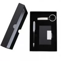 Kit executivo 3 peças em estojo de papelão com tampa e parte interna revestida de espuma. Contém: chaveiro metal fosco com detalhe emborrachado preto, porta cartão de couro sintético(verso metálico liso) com placa de metal e caneta metal fosca com detalhe emborrachado preto. Acompanha placa metálica para gravação.