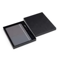 Kit executivo composto por dois itens: uma caderneta tipo moleskine e uma caneta. A caderneta possui capa em PU, fecho em elástico, marca-páginas em fita de cetim e cerca de 80 folhas marfim pautadas. A caneta metálica possui detalhes em plástico e carga esferográfica preta de 0,8 mm. Acompanha caixa em papelão com berço em PET com revestimento aveludado para acomodação dos itens.