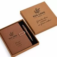 Kit executivo composto por dois itens: uma caderneta e uma caneta. A caderneta possui capa dura em couro sintético texturizado com fecho magético e alça metálica com detalhe em couro sintético, marca-páginas em fita de cetim e aproximadamente 120 folhas marfim pautadas. A caneta metálica conta com clipe, acionamento por rotação e carga esferográfica preta de 1,0mm. Acompanha caixa em papelão com berço removível em espuma para acomodação da caneta.  Altura :  23 cm  Largura :  19,8 cm  Profundidade :  2,9 cm