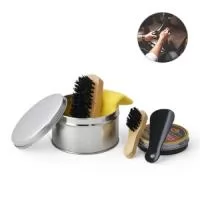 Kit de limpeza de sapatos. Com 6 peças: 1 cera incolor para sapatos, 1 flanela amarela, 2 escovas em madeira, 1 calçadeira e 1 embalagem lata. Gravação da logomarca a laser já inclusa.