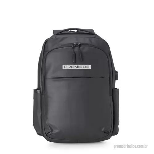 Mochila personalizada - A mochila é feita de couro sintético e possui compartimentos para notebook de até 15,6 polegadas, documentos e eletrônicos. Tem dois bolsos frontais (um com divisórias para documentos e caneta), um bolso traseiro oculto, e dois bolsos laterais. Inclui um adaptador USB externo para conectar um carregador portátil e usar o celular enquanto carrega. O tecido é impermeável e a mochila conta com zíperes com pegadores plásticos, alça de mão em nylon e alças ajustáveis com revestimento espumado antitranspirante. Dimensões: 44 cm x 35 cm x 13 cm. É ideal para uso executivo.