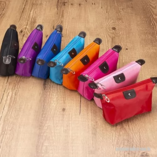 Nécessaire personalizado - Descrição: Nécessaire impermeável de poliéster com detalhes em couro sintético e parte interna com revestimento emborrachado, possui um “botão” no detalhe do couro frontal.  Altura :  10 cm  Largura :  19 cm