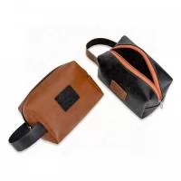 Necessaire de couro sintético bidins com alça para transporte, possui placa frontal para personalização e área interna revestida de nylon. Altura : 14 cm profundidade : 10,5 cm com alça 23,5 cm. Peso aproximado (g): 87. GRAVAÇÃO: Silk Screen 1 cor ou Transfer full cor.