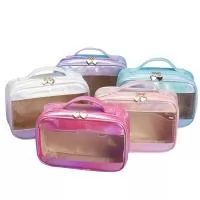 Nécessaire confeccionada em PVC e tecido sintético com design holográfico e resistente à água, com alça superior, abertura com ziper e pingente de coração, tamanho aproximado 17 x 23 x 8 cm.