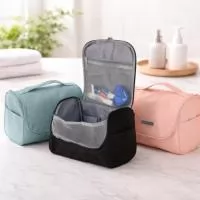 Nécessaire organizadora confeccionada em poliéster impermeável. Conta com bolso interno em tela de nylon com fechamento em zíper, três bolsos abertos e gancho plástico para mantê-la pendurada quando aberta. Acompanha placa personalizável plástica.
