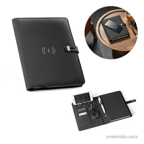 Pasta executiva personalizada - Pasta A5 em 300D poliéster reciclado (100% rPET) com carregador wireless embutido. A bateria tem capacidade para 5.000 mAh, potência de 10W, entrada/saída 5V/2.1A e cabo USB tipo C para carregar a bateria. A pasta contém no seu interior um bolso para smartphone até 6.5'', três espaços para cartões, quatro luzes LED, botão on/off, suportes para esferográfica (não inclusa), celular e cabo USB, um bloco de notas com capa em cartão preto e 64 folhas pautadas de cor marfim, em papel proveniente de gestão florestal sustentável. Na frente existe ainda uma impressão oval em preto para indicar a área de carga do wireless. Fornecido em caixa presente. Medidas: 165 x 225 x 25 mm
