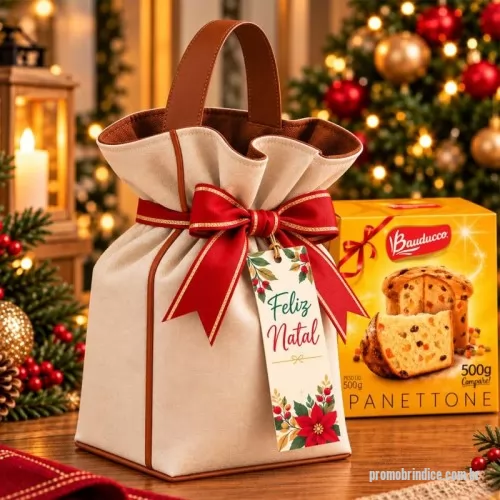 Porta panetone personalizada - Porta-panetone 500g confeccionado em lona de algodão cru, com forro interno marrom, alça reforçada em couro sintético e acabamento externo no mesmo material. Possui fechamento com laço decorativo e tag natalina personalizada.  Medidas: Comprimento: 18 cm Altura: 25 cm Largura: 18 cm  Pedido mínimo de 100 unidades  *Produto não acompanha panetone