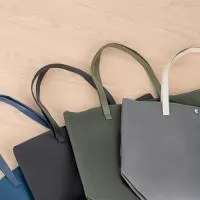 Sacola em Couro Sintético Personalizada – Fabricação Própria  A Sacola em Couro Sintético Personalizada é um produto sofisticado, resistente e de alto valor agregado, ideal para empresas que desejam transmitir elegância e profissionalismo em suas ações promocionais. Com acabamento premium, é uma excelente opção para brindes corporativos de impacto e uso diário.  Confeccionada em couro sintético à base de PVC, a sacola oferece durabilidade, fácil limpeza e aparência refinada. Possui alças com costura externa reforçada e fechamento com botões magnéticos metálicos, garantindo praticidade e segurança no uso.  Seu interior conta com revestimento em poliéster e bolso interno compacto com zíper, proporcionando organização e funcionalidade para transportar itens pessoais, materiais de trabalho ou brindes.  A EV Brindes, com fábrica própria, desenvolve sacolas personalizadas em diversos materiais, cores e tamanhos, permitindo total personalização de acordo com a identidade visual da sua marca. 