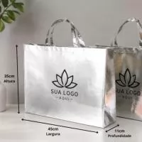 Descrição: Sacola TNT metalizada 110g/m² com botão. Confeccionado em TNT com revestimento plástico laminado, parte superior possui botão plástico para fecho.  Altura :  35 cm  Largura :  45,5 cm  Profundidade :  13,5 cm