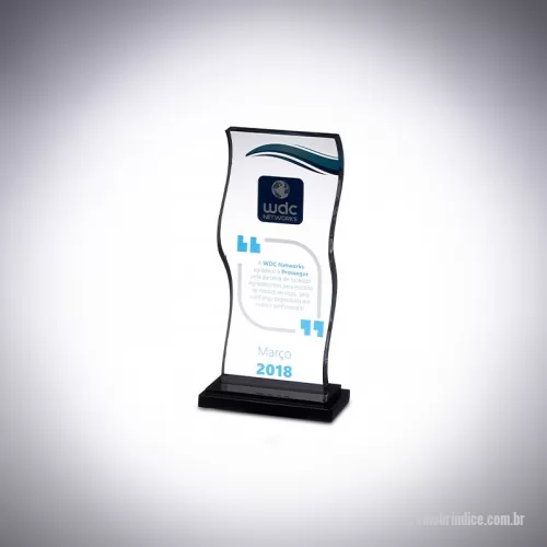 Troféu personalizado - O troféu de acrílico personalizado, criado exclusivamente para a WDC, celebra o reconhecimento dos colaboradores essenciais para o crescimento da empresa, destacando-se com uma haste robusta e design retangular único, adornado com cortes que lembram ondas.  Com uma base preta de acrílico e plaquinha de aço escovado, sua confecção utiliza corte a laser e técnicas de colagem, complementadas por impressão UV para um acabamento de alta qualidade.  Desenvolvido em colaboração direta com o cliente, que participou de cada etapa de aprovação, oferecemos troféus sob medida que realçam o valor e a distinção de momentos especiais. Personalize seu troféu de acrílico na AD Plastic para um reconhecimento memorável e elegante.